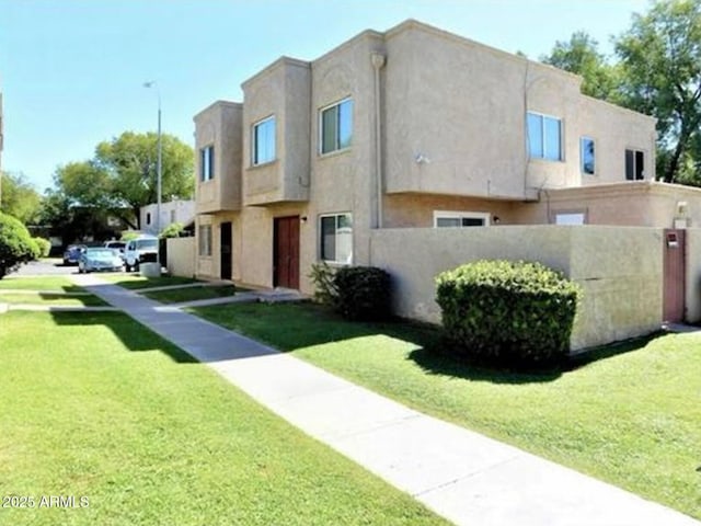 view of front of house featuring a front lawn and stucco siding