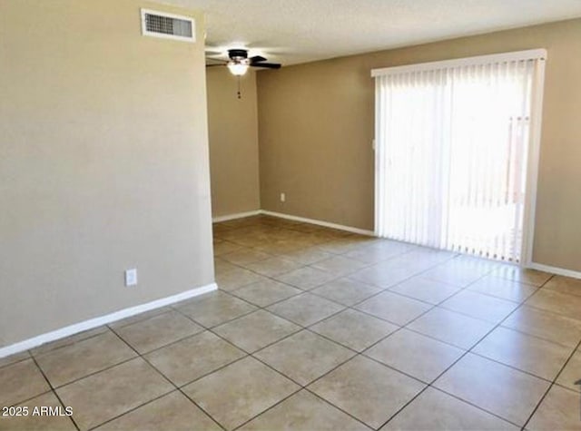 spare room with a ceiling fan, visible vents, and light tile patterned flooring