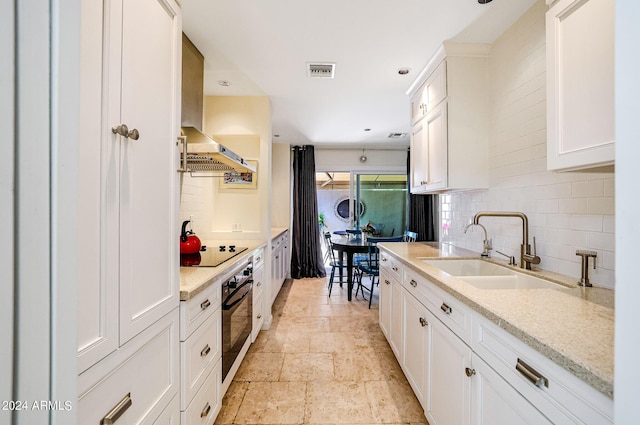 361 E Palm Ln, Phoenix, AZ 85004 - kitchen featuring tasteful backsplash, ventilation hood, black appliances, white cabinetry, and light stone finish floors