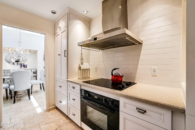 361 E Palm Ln, Phoenix, AZ 85004 - kitchen featuring black appliances, wall chimney exhaust hood, backsplash, a chandelier, and white cabinets
