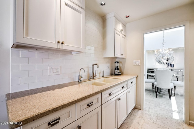 361 E Palm Ln, Phoenix, AZ 85004 - kitchen with backsplash, white cabinetry, light stone counters, a chandelier, and recessed lighting