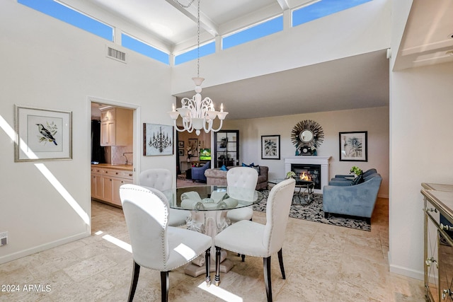 361 E Palm Ln, Phoenix, AZ 85004 - dining room featuring a glass covered fireplace, a chandelier, and a high ceiling