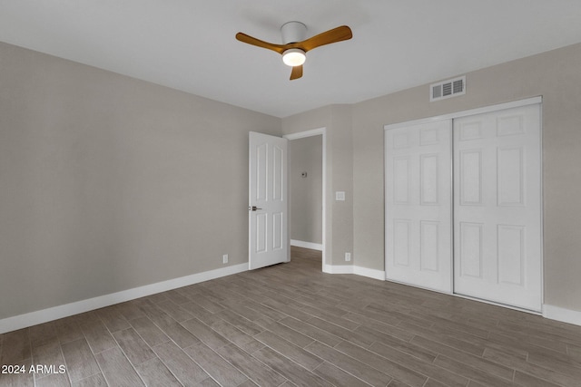 unfurnished bedroom with hardwood / wood-style flooring, a closet, and ceiling fan