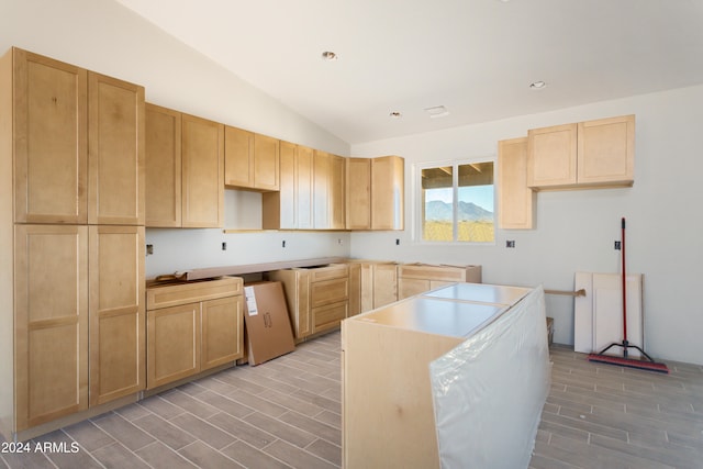 kitchen with vaulted ceiling and light brown cabinets