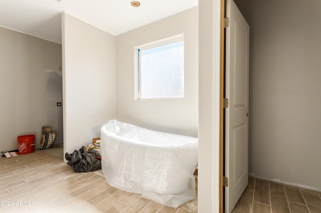 bathroom featuring wood-type flooring and a tub