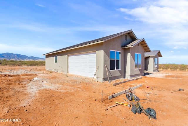 view of home's exterior with a garage and a mountain view