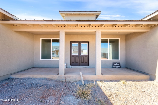 view of exterior entry with a patio