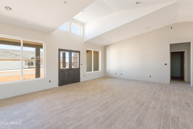 interior space featuring french doors, vaulted ceiling, and light wood-type flooring