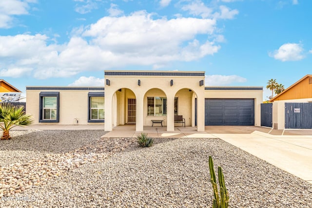 mediterranean / spanish home with driveway, fence, an attached garage, and stucco siding