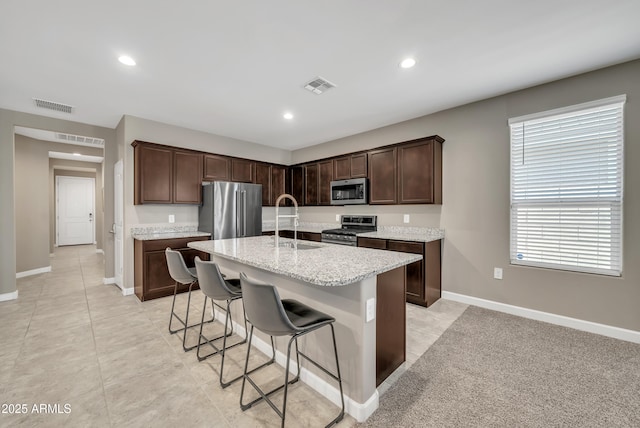 38150 W San Sisto Ave, Maricopa, AZ 85138 - kitchen with appliances with stainless steel finishes, baseboards, a kitchen breakfast bar, dark brown cabinetry, and recessed lighting