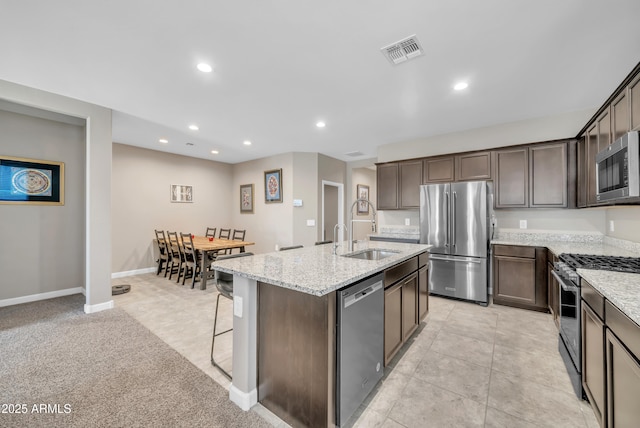 38150 W San Sisto Ave, Maricopa, AZ 85138 - kitchen featuring stainless steel appliances, a sink, recessed lighting, dark brown cabinets, and light stone countertops