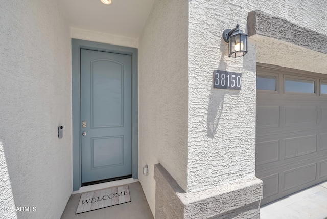 38150 W San Sisto Ave, Maricopa, AZ 85138 - doorway to property featuring stucco siding and a garage