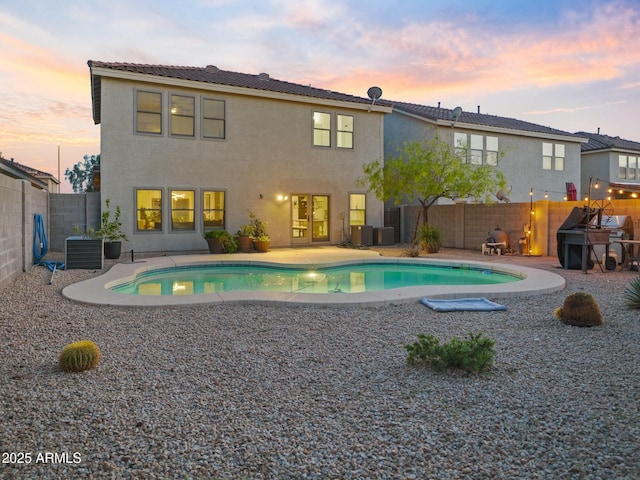5110 E Peak View Rd, Cave Creek, AZ 85331 - back of property at dusk with a fenced backyard, stucco siding, a patio, and a fenced in pool