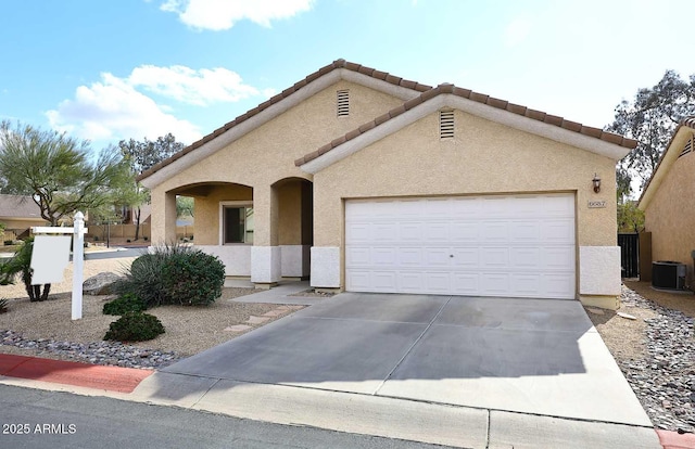 view of front of property featuring a garage and central air condition unit