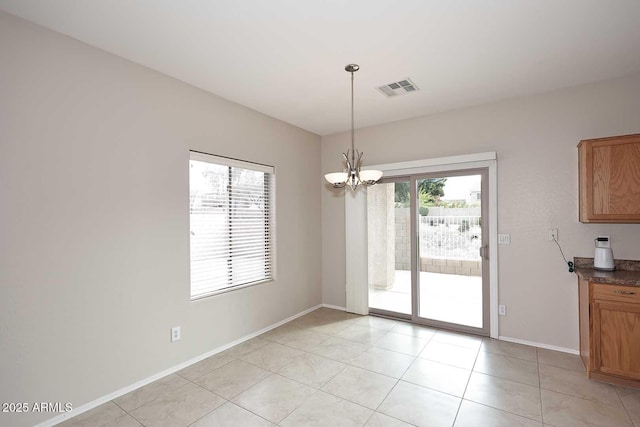 unfurnished dining area featuring light tile patterned flooring and a notable chandelier