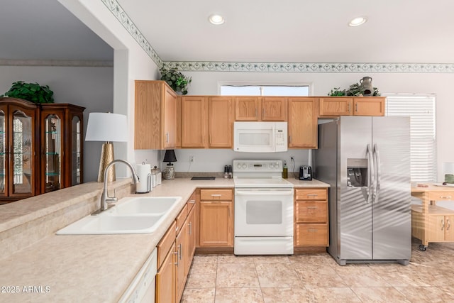 kitchen featuring recessed lighting, white appliances, light countertops, and a sink