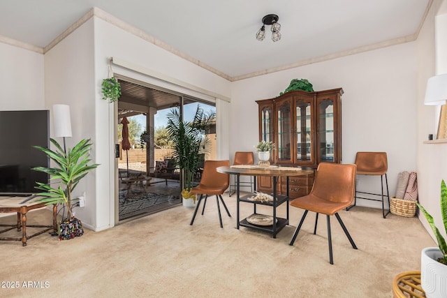 carpeted dining area with ornamental molding