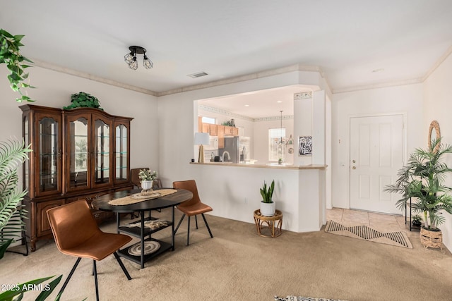 carpeted dining room featuring visible vents and ornamental molding