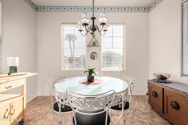 dining room with a notable chandelier and baseboards