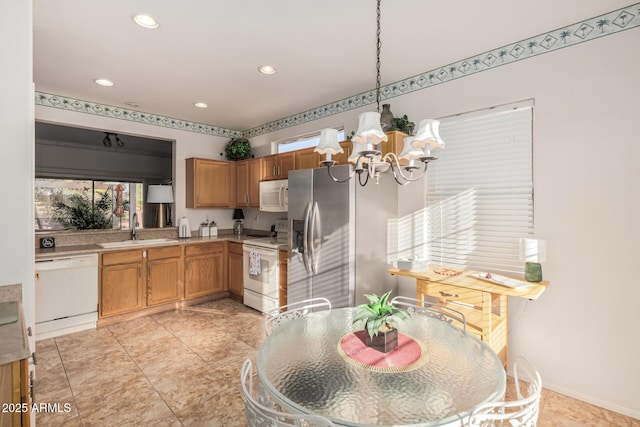 kitchen with white appliances, recessed lighting, a sink, light countertops, and a chandelier