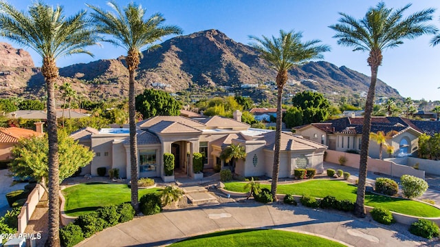 view of front of house with a mountain view and a front lawn