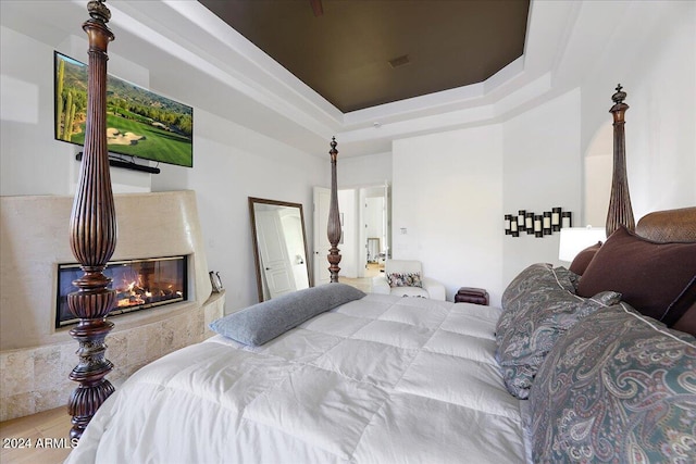 bedroom featuring a premium fireplace and a raised ceiling