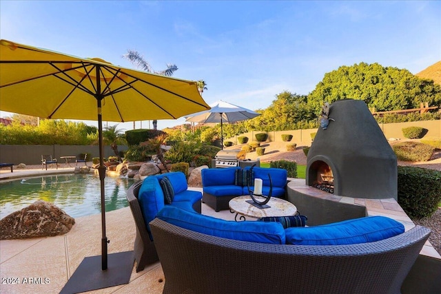 view of patio with an outdoor living space with a fireplace and a fenced in pool