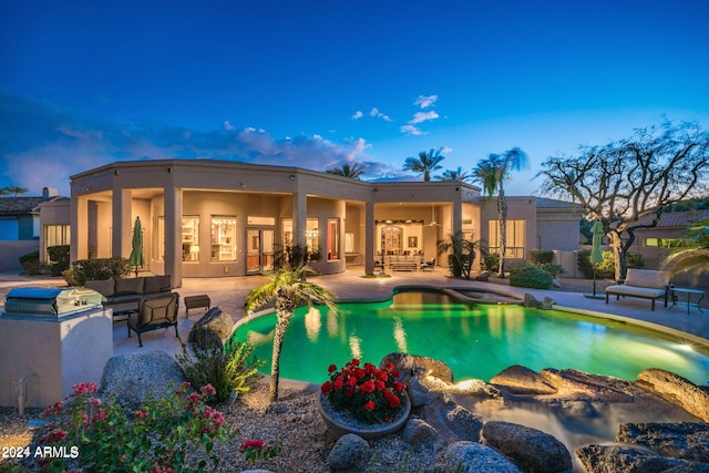 pool at dusk with an outdoor hangout area and a patio area