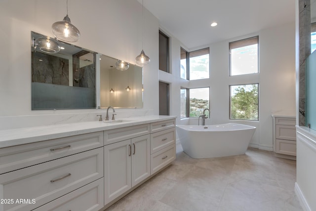 bathroom with a high ceiling, walk in shower, a freestanding tub, and vanity