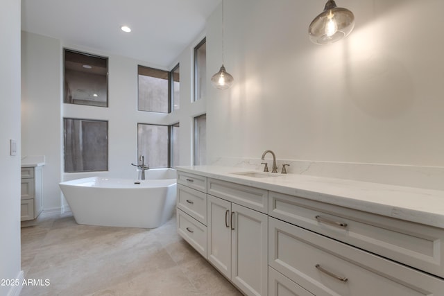 bathroom with a soaking tub, a high ceiling, and vanity