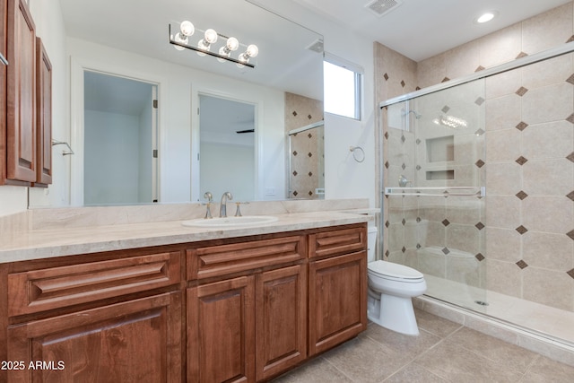 bathroom with visible vents, toilet, a shower stall, vanity, and tile patterned flooring