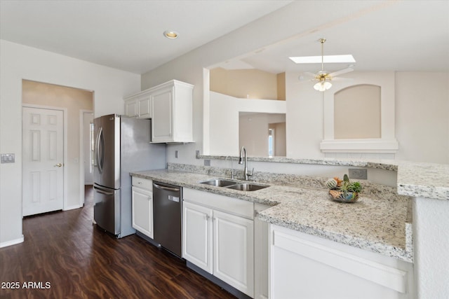 kitchen with appliances with stainless steel finishes, white cabinetry, sink, dark hardwood / wood-style flooring, and light stone countertops