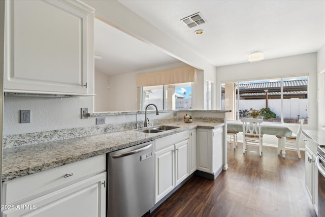 kitchen featuring dishwasher, sink, light stone countertops, and white cabinets