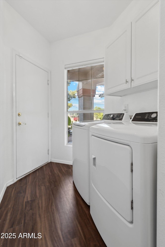 laundry room featuring cabinets, dark hardwood / wood-style flooring, and washing machine and clothes dryer