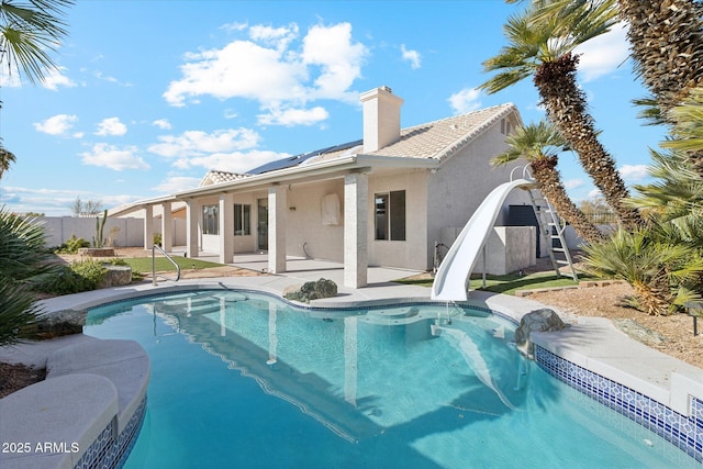 back of property featuring a fenced in pool and a patio