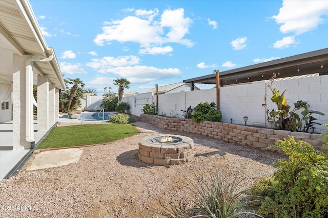 view of yard with a swimming pool and a fire pit