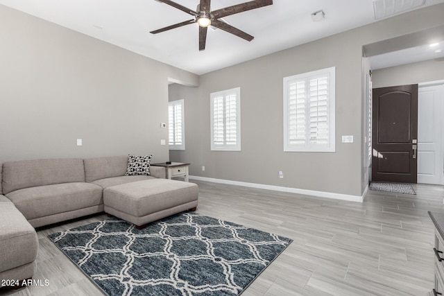 living room with light hardwood / wood-style floors and ceiling fan