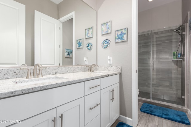 bathroom featuring toilet, vanity, and a shower with door