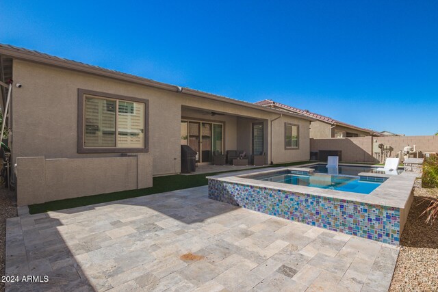 back of house featuring a patio area and a swimming pool with hot tub