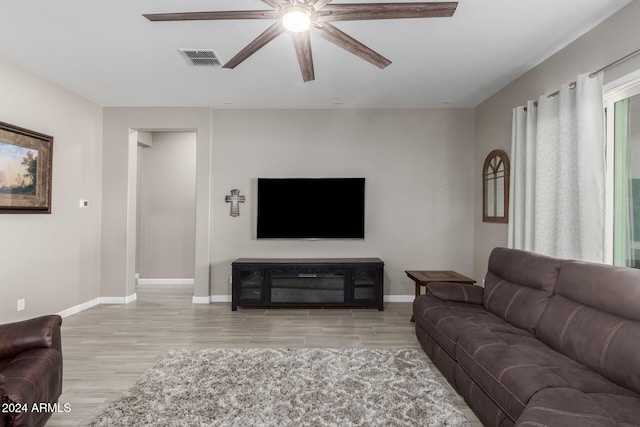 living room featuring light hardwood / wood-style floors and ceiling fan