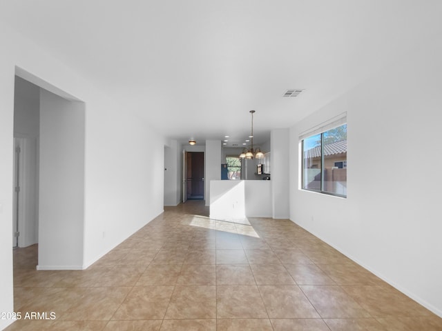 unfurnished room with an inviting chandelier, light tile patterned floors, and visible vents