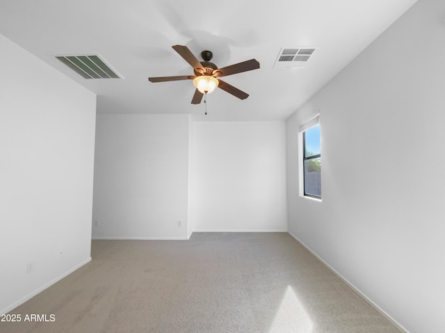 carpeted spare room with a ceiling fan, visible vents, and baseboards