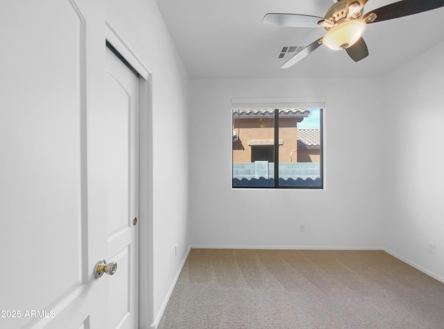 empty room with carpet flooring, baseboards, and a ceiling fan