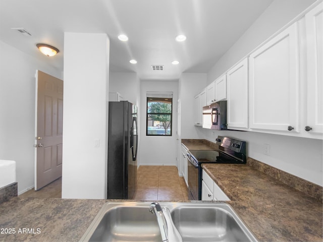 kitchen featuring dark countertops, visible vents, black appliances, white cabinetry, and a sink