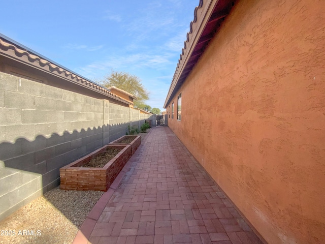 view of property exterior featuring a garden, stucco siding, and a fenced backyard