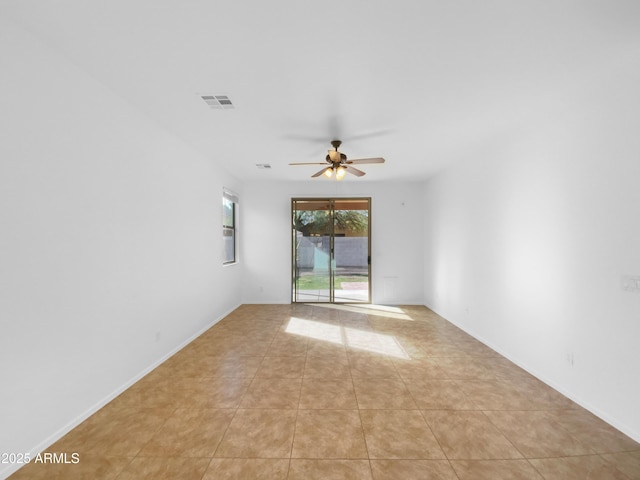 empty room with light tile patterned floors, baseboards, visible vents, and ceiling fan