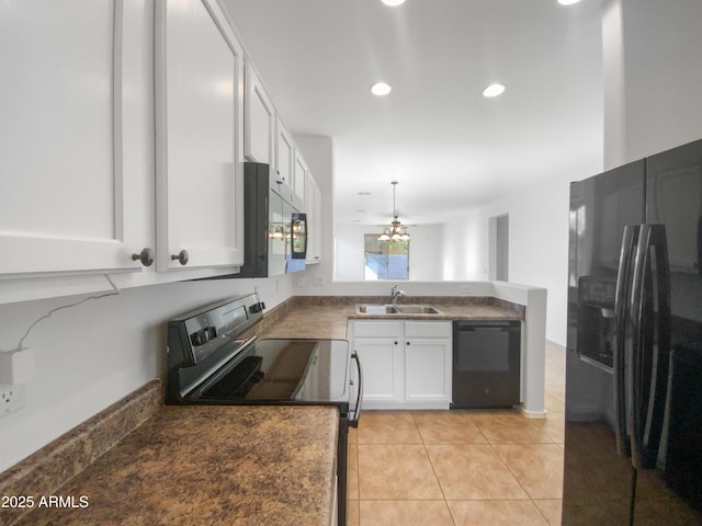 kitchen featuring light tile patterned floors, a peninsula, white cabinets, black appliances, and a sink