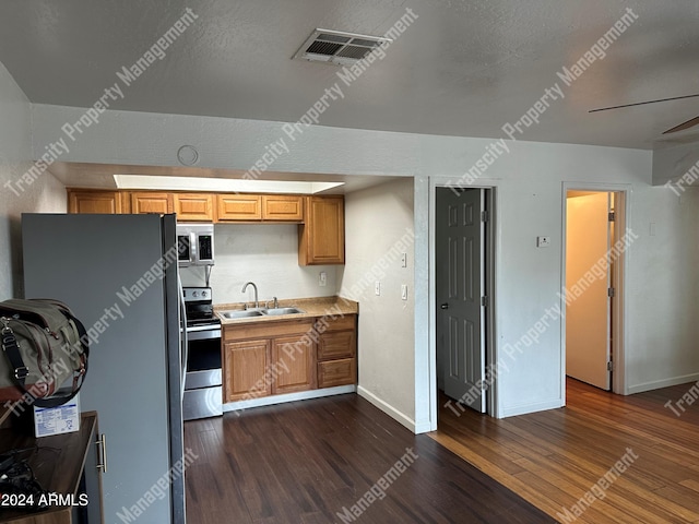 kitchen featuring sink, ceiling fan, dark hardwood / wood-style flooring, and stainless steel appliances