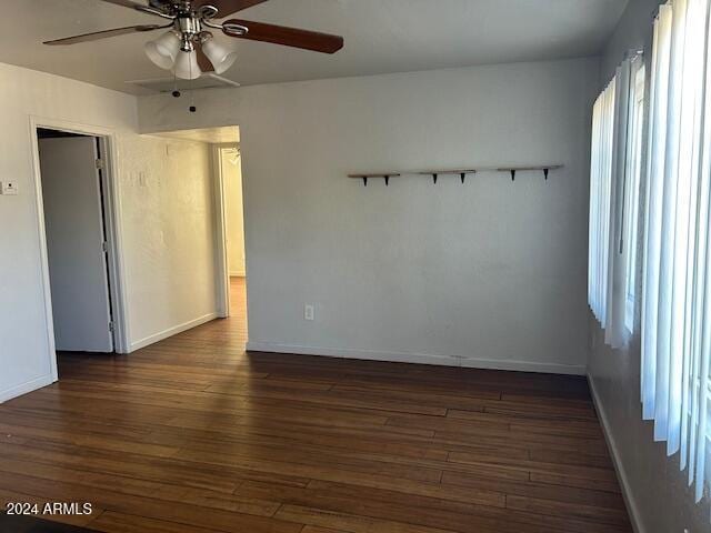 spare room featuring ceiling fan and dark wood-type flooring