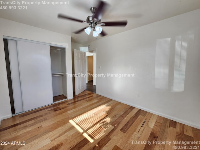 unfurnished bedroom featuring light hardwood / wood-style floors, a closet, and ceiling fan